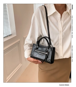 Detail view of black PU leather handbag showing texture and adjustable shoulder strap style