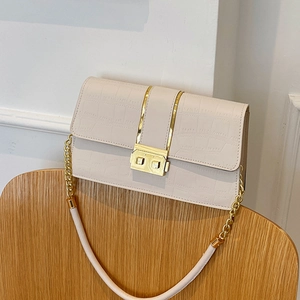 Chic cream crocodile pattern crossbody bag with gold chain strap on a wooden chair
