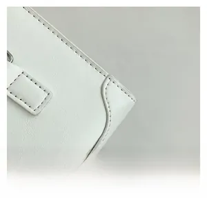 Close-up of white leather handbag edge with neat stitching and premium texture detail