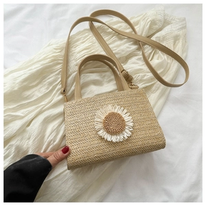 Macro detail of natural straw woven texture and 3D daisy flower on a summer handbag