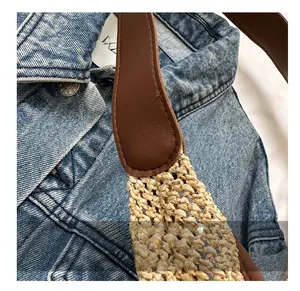 Detail shot of durable reinforced leather strap stitching on woven tote shoulder bag