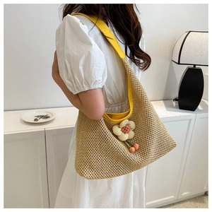 Chic woven tote bag with flower detail shown on a female model in a home setting