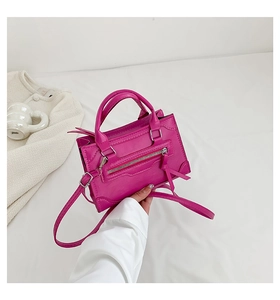 Detail of rose red mini crossbody bag with metal zipper and fine leather texture