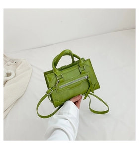 Detail of small matcha green crossbody tote with decorative zipper and leather texture
