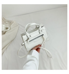 Detail of white minimalist mini tote bag with silver zipper and long leather tassel decoration