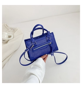 Detail of royal blue PU leather handbag with metallic zipper and tassel decoration