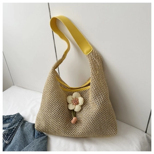 Macro detail of hand-woven mesh tote bag with yellow leather strap and fabric flower