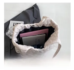 Macro view of beige quilted tote bag interior showing spacious capacity for tablets