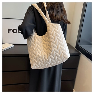 Close-up detail of white quilted tote bag featuring creative leaf-pattern stitching