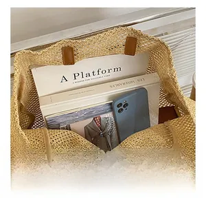 Top view detail of large woven tote bag with brown leather trim and spacious interior