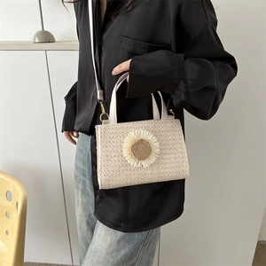 Minimalist cream woven crossbody bag with decorative daisy flower and gold hardware
