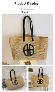 Detail of straw tote bag with black leather straps and circular logo in home setting