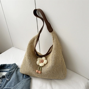 Large khaki straw shoulder bag with floral accent and plush balls for summer vacation