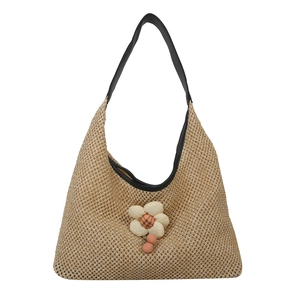 Large woven floral tote bag with black shoulder strap and pink flower charm accent