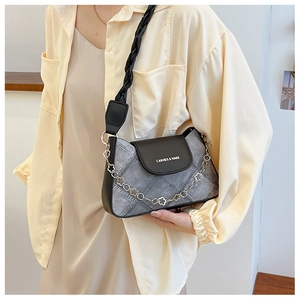 Detail of dark grey denim underarm bag featuring flower metal chain and black leather flap
