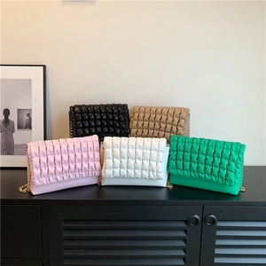 Quilted bubble texture crossbody bag shown in five vibrant colors with gold chain straps