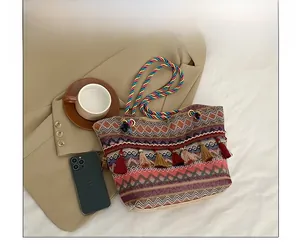 Detail of bohemian woven tote bag with colorful geometric patterns and fringe tassel charm