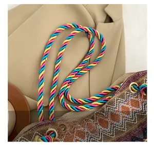 Detail of bohemian woven tote bag showing colorful braided handles and geometric patterns