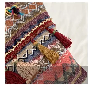 Macro detail of bohemian woven pattern and colorful silk tassels on a tote bag