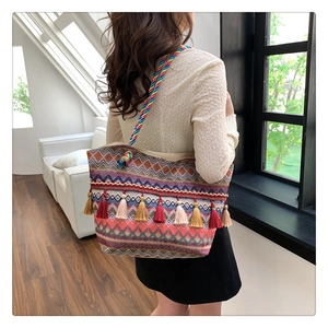 Detail of bohemian woven tote bag with colorful tassels and geometric stripe patterns