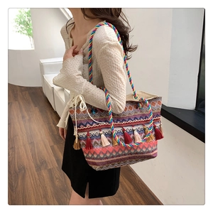 Close-up of bohemian woven tote bag with colorful geometric patterns and tassel detail