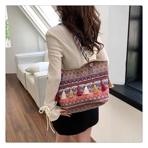 Detail of bohemian tote bag with colorful geometric patterns and long tassel charms