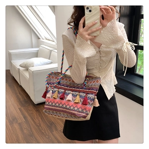 Detail of bohemian tote bag featuring colorful geometric patterns and decorative tassels