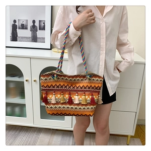 Detail of colorful bohemian woven tote bag featuring vibrant tassels and rainbow rope handle