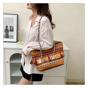 Detail of bohemian tote bag featuring colorful tassels and woven textured pattern