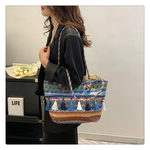 Detail of bohemian tote bag featuring colorful woven patterns and tassel fringe accents