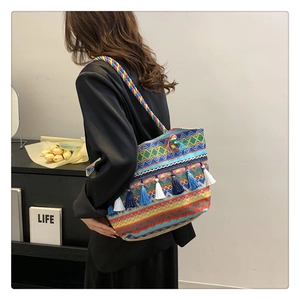 Detail of bohemian woven tote bag with colorful geometric patterns and fringe charms