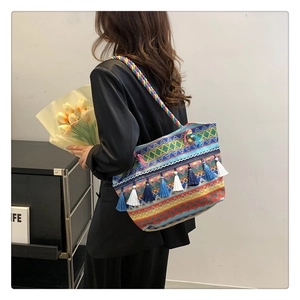 Detail of colorful woven tote bag with ethnic geometric patterns and stylish long tassels