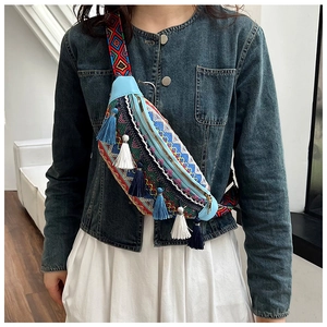 Détail d'un sac bandoulière ethnique avec broderies colorées et pompons décoratifs