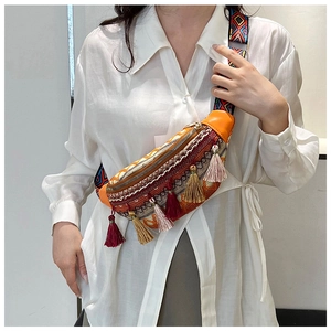 Gros plan du sac de poitrine ethnique avec pompons colorés et bandoulière tissée