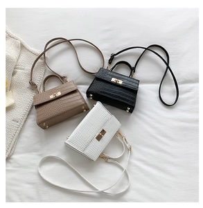 Detailed close-up of crocodile embossed leather texture and gold twist locks on mini bags