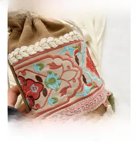 Close-up of ethnic embroidery and colorful tassel details on the canvas bucket bag