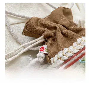 Detailed view of colorful floral embroidery and cotton drawstring on a canvas bucket bag