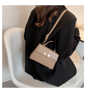 Rear view of a khaki crocodile-embossed trapezoid crossbody bag shown on a model