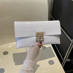 Dettaglio della pochette a busta bianca con trama coccodrillo e fibbia in oro