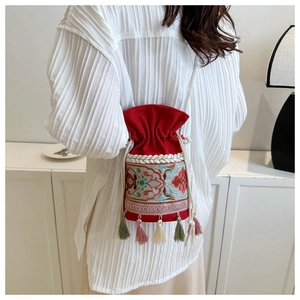 Close-up of ethnic bucket bag featuring colorful embroidery and tassel detail