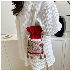 Detailed embroidery and colorful tassels on a red ethnic drawstring bucket bag