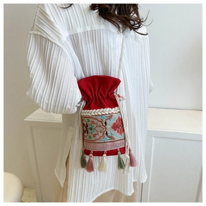 Ethnic style red embroidery bucket bag with colorful floral patterns and tassels