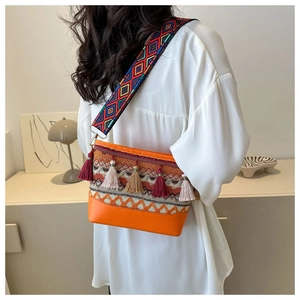 Nahaufnahme der Boho-Schultertasche mit ethnischen Webmustern und bunten Quastenanhängern