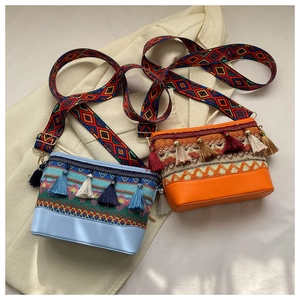 Detailaufnahme von Ethno-Umhängetaschen mit bunten Fransen und Webmustern im Boho-Stil