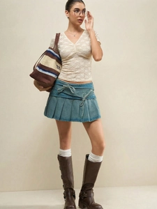 Lace V-neck top and pleated denim mini skirt paired with stylish brown leather boots