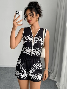 Detailed view of black floral vest and drawstring shorts set with white hollow patterns