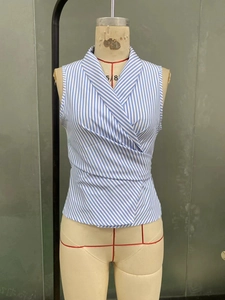 Detail of blue and white striped sleeveless shirt showing waist tie and wrap design