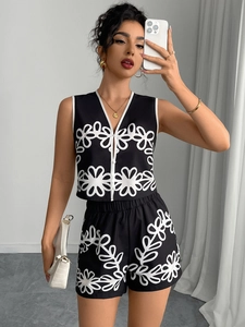 Close-up of black sleeveless V-neck vest and matching floral shorts with white buttons