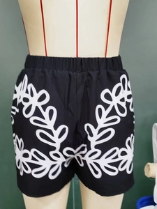 Detail of black shorts with white floral embroidery and comfortable elastic waistband