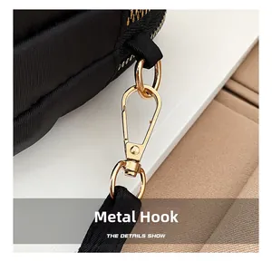 Close-up of premium golden metal hardware hook and durable black nylon strap stitching